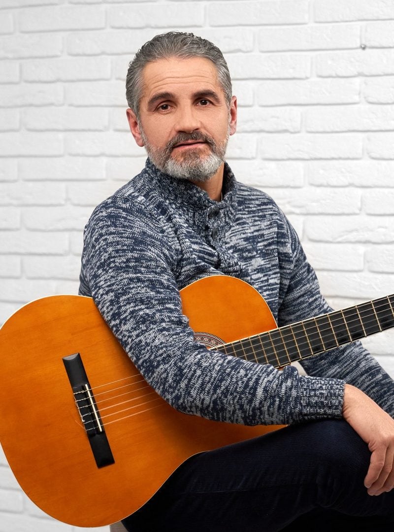 mature man posing in studio with guitar e1648791556526
